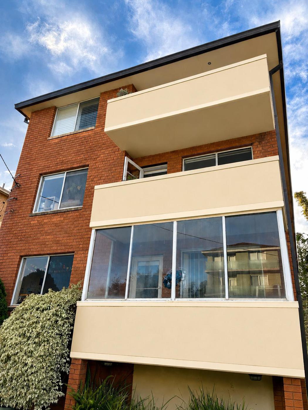 Same apartment balconies restored to clean cream render after pressure washing